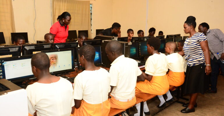 Students learning computer skills in a donated school computer lab in Uganda